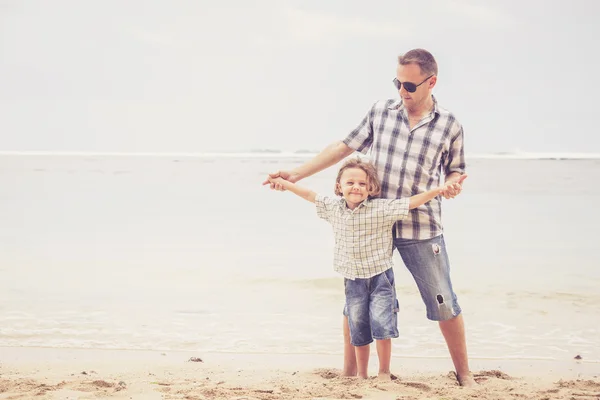 Father and son playing on the beach at the day time. — Stock Photo, Image