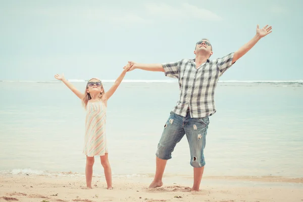 Padre e hija jugando en la playa durante el día . — Foto de Stock