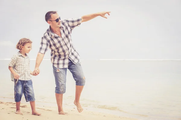 Padre e hijo jugando en la playa durante el día . — Foto de Stock