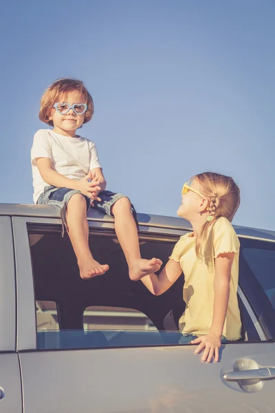 Feliz irmão e irmã estão sentados no carro — Fotografia de Stock