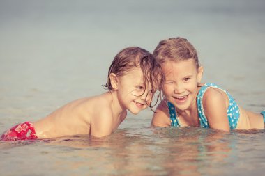 Kumsalda oynarken iki mutlu çocuk