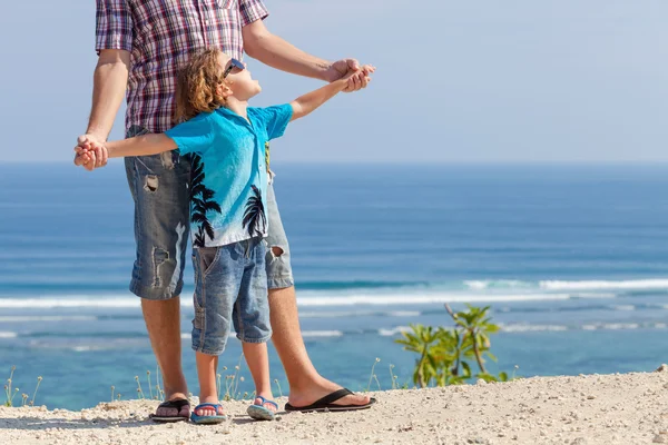 Vader en zoon spelen op het strand op het moment van de dag. — Stockfoto