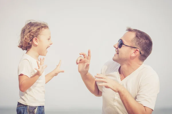 Padre e hijo jugando en la playa durante el día . — Foto de Stock