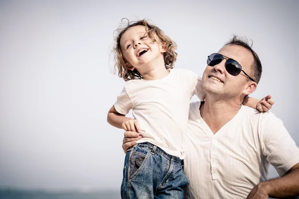 Pai e filho brincando na praia na hora do dia . — Fotografia de Stock