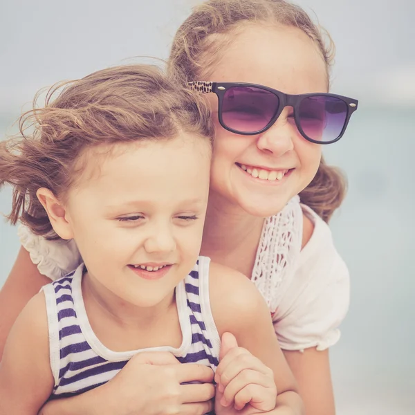 Hermana y hermano jugando en la playa durante el día . — Foto de Stock