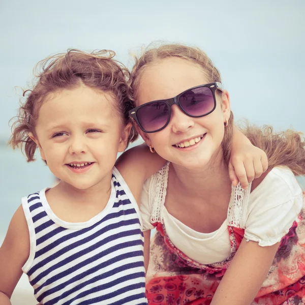 Hermana y hermano jugando en la playa durante el día . — Foto de Stock