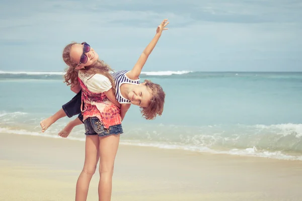 Schwester und Bruder spielen tagsüber am Strand. — Stockfoto