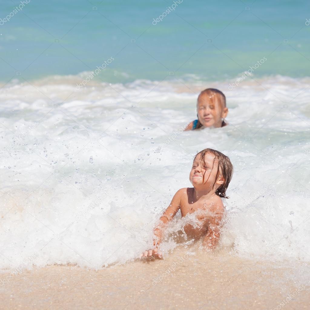 Sister and brother playing on the beach at the day time.