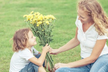 Anne ve oğlu çimlere gün anda oynamak.