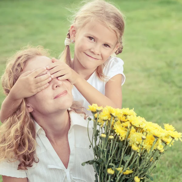 Moeder en dochter spelen op het gras op het moment van de dag. — Stockfoto