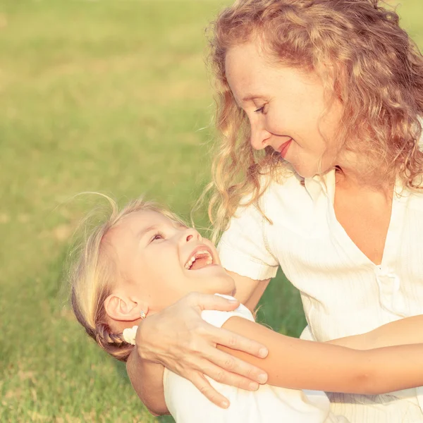 Moeder en dochter spelen op het gras op het moment van de dag. — Stockfoto