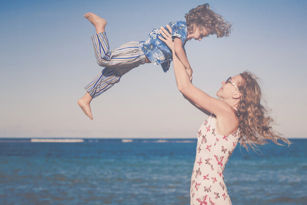 Mother and son playing on the beach at the day time.