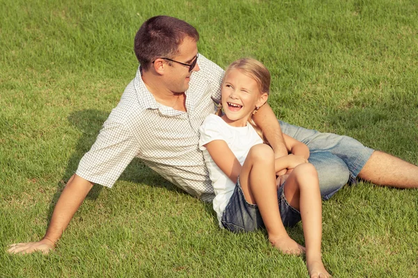 Isä ja tytär leikkivät nurmikolla päivällä . — kuvapankkivalokuva