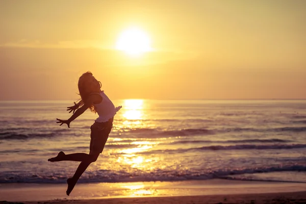Happy little girl jumping on the beach Stock Image