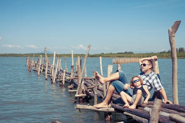 Baba ve oğul denizde köprüde gün anda dinlenme. — Stok fotoğraf