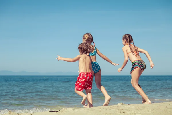 Deux sœurs et frère jouant sur la plage — Photo