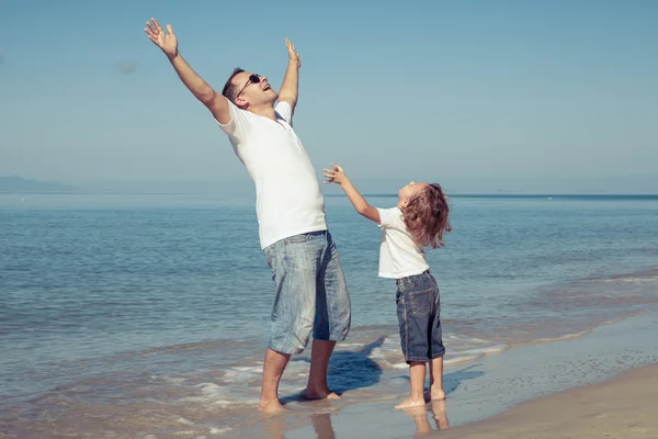Pai e filho brincando na praia na hora do dia . — Fotografia de Stock