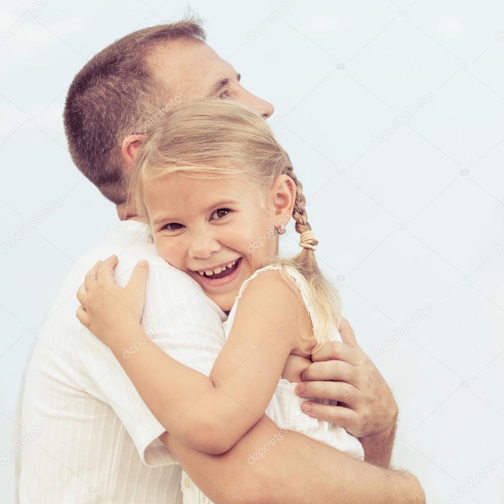 Dad and daughter playing near a house at the day time