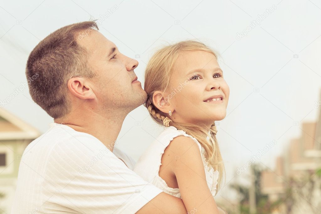 Dad and daughter playing near a house at the day time