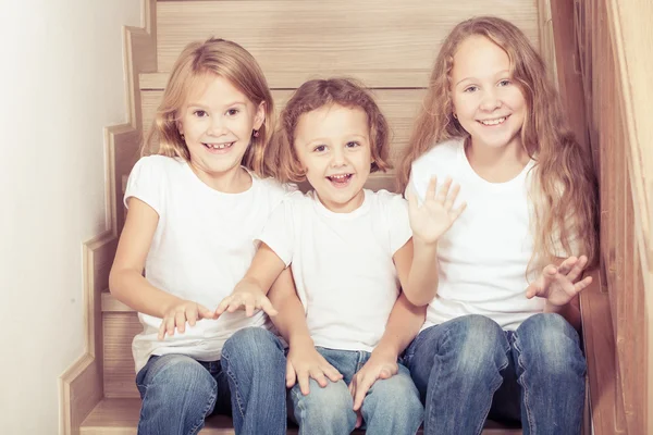 Portrait of happy children which are sitting on the stairs in th — Stock Photo, Image