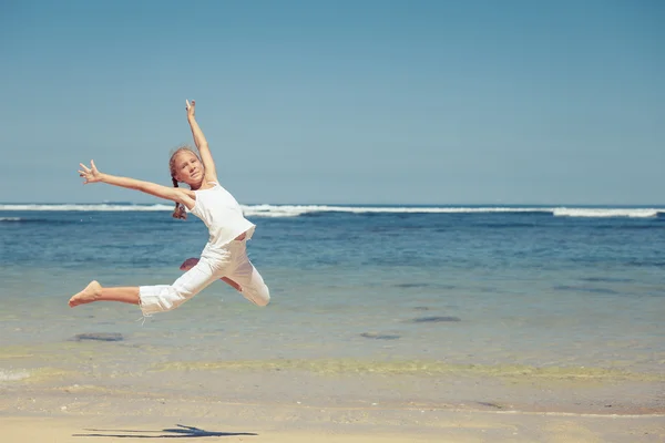 Дівчина-підліток стрибає на пляжі на блакитному морському березі влітку — стокове фото