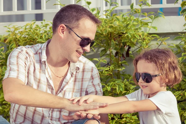 Vader en zoon spelen in de buurt van een huis op het moment van de dag. — Stockfoto