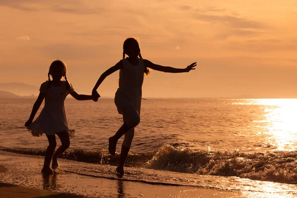 Gelukkig meisjes springen op het strand — Stockfoto