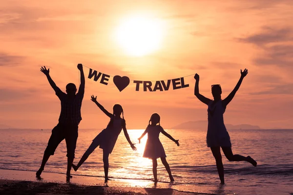 Happy family standing on the beach at the sunset time. — Stock Photo, Image