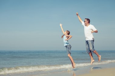 Baba ve kızı kumsalda gün anda oynamak.