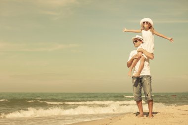 Baba ve kızı kumsalda gün anda oynamak.