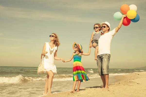 Lycklig familj spelar med ballonger på stranden på dagarna — Stockfoto