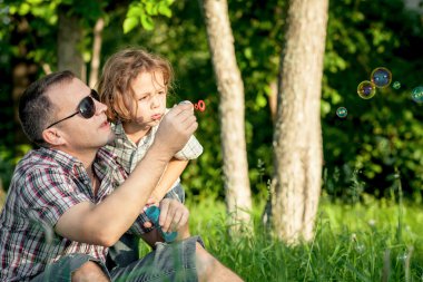 Baba ve oğul gün anda parkta oynamak.