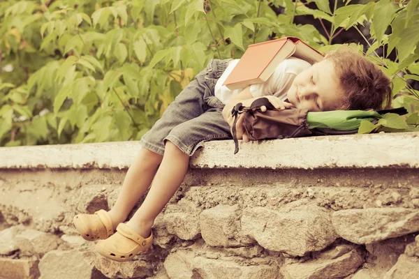 Bambino con libro sdraiato nel parco — Foto Stock