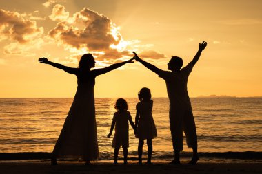 mutlu aile silüeti sunse plajda oynayan