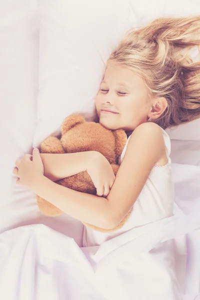 Lovely little girl sleeping on the bed at home — Stock Photo, Image