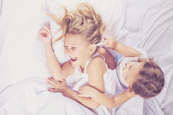 Lovely brother and sister lying in bed at home. — Stock Photo, Image