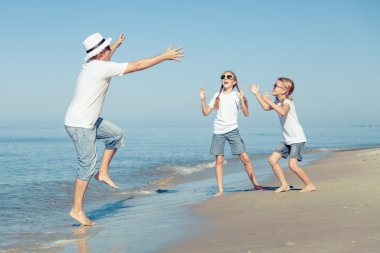 Baba ve kızı kumsalda gün anda oynamak. 
