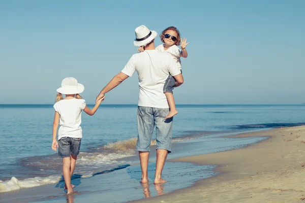 Vater und Kinder spielen tagsüber am Strand. — Stockfoto