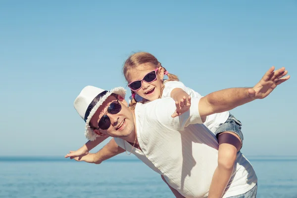 Vater und Tochter spielen tagsüber am Strand. — Stockfoto