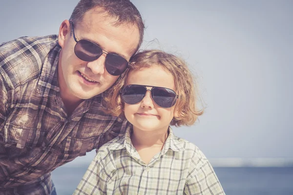 Far och son som spelar på stranden på dagarna. — Stockfoto