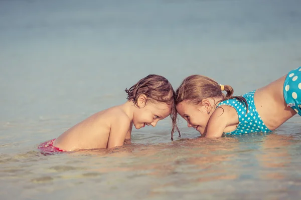 Два счастливых ребенка играют на пляже — стоковое фото