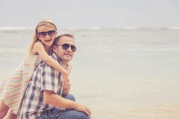 Far och dotter spelar på stranden på dagarna. — Stockfoto