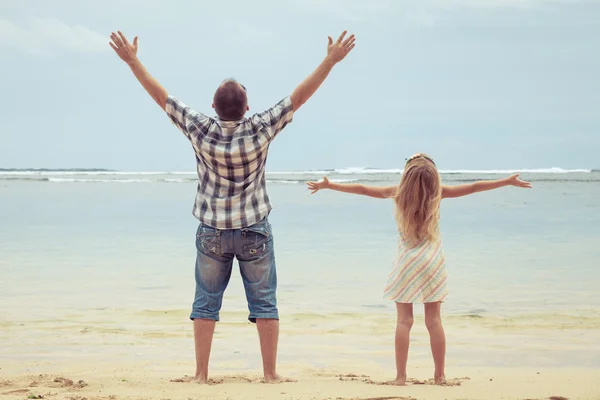 Vader en dochter spelen op het strand op het moment van de dag. — Stockfoto