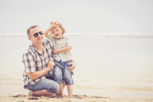 Padre e figlio che giocano sulla spiaggia durante il giorno . — Foto Stock