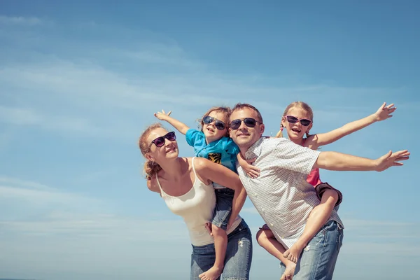 Glad familj står på stranden på dagarna. — Stockfoto