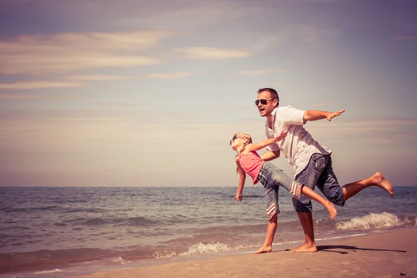 Pai e filha brincando na praia no dia . — Fotografia de Stock