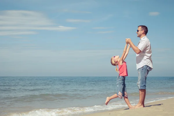 Pai e filha brincando na praia no dia . — Fotografia de Stock