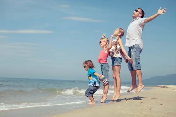 Far och barn som leker på stranden på dagarna. — Stockfoto