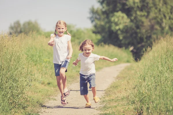 Två glada barn som leker på vägen — Stockfoto