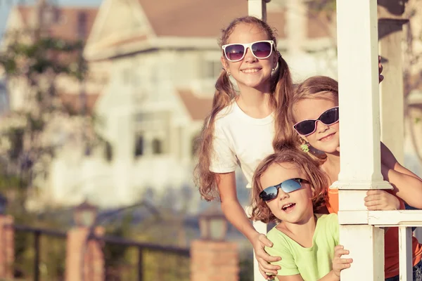 Niños felices jugando cerca de la casa durante el día . — Foto de Stock